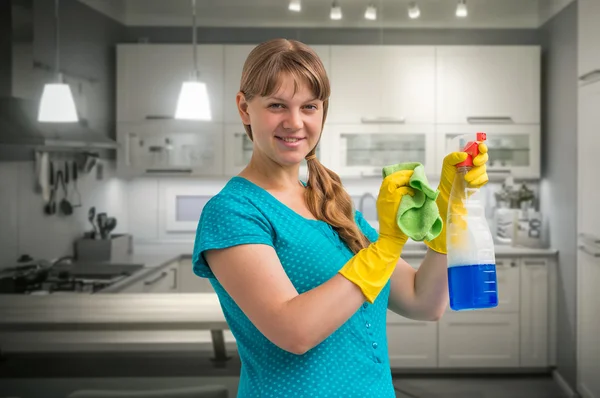 Young smiling housewife woman cleaning kitchen — Stock Photo, Image