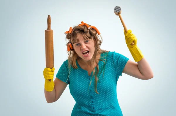 Сумасшедшая домохозяйка с кухонным роликом и мясным молотком — стоковое фото