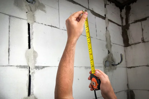 Trabalhador com fita métrica em centímetros e pés — Fotografia de Stock