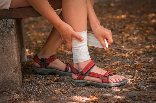 Kvinna tillämpa komprimering bandage på hennes ben — Stockfoto