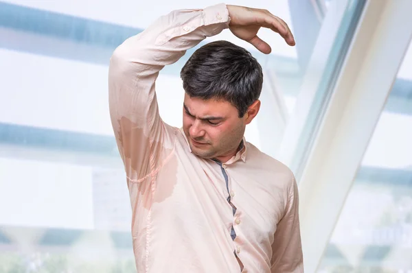 Hombre con hiperhidrosis sudando bajo la axila en la oficina —  Fotos de Stock
