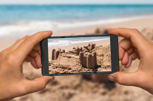 Toma de fotos del castillo de arena con teléfono móvil — Foto de Stock