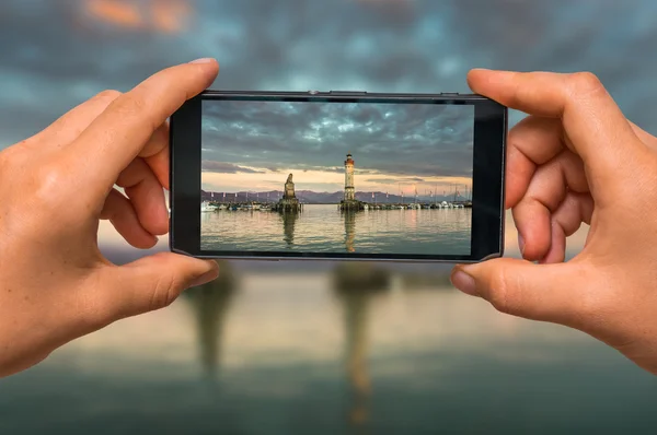 Tomar foto del faro en el puerto con teléfono móvil — Foto de Stock