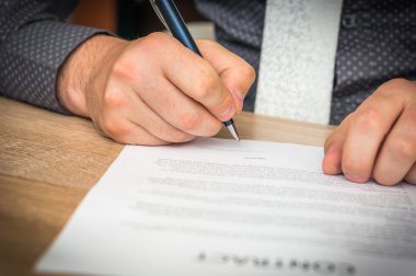 İşadamı bir anlaşma sonuçlandırmak için bir sözleşme imzalama