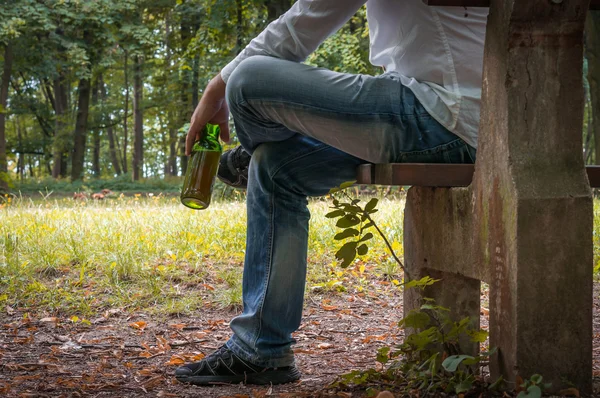 벤치에 앉아 맥주 병으로 술 취한 사람을 우울 — 스톡 사진