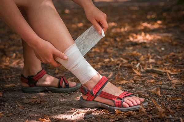 Kvinna tillämpa komprimering bandage på hennes ben — Stockfoto