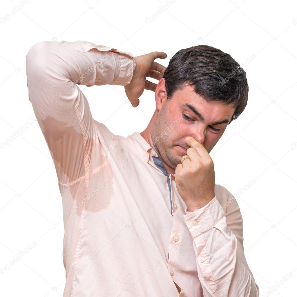 Man with sweating under armpit pinches nose with fingers