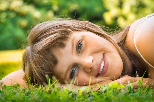 Joven hermosa adolescente acostada en la hierba verde — Foto de Stock