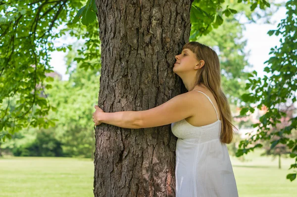 Femme heureuse embrassant un arbre dans la forêt — Photo
