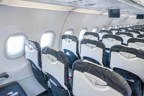 Airplane cabin and comfortable seats in economy class inside of plane