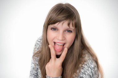 Çekici bir kadın dilini gösteriyor ve ona iki parmakla dokunuyor.