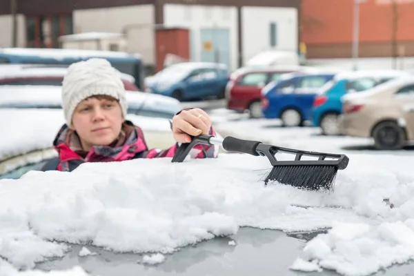 Kvinnelig Sjåfør Vasker Snø Med Pensel Fra Biltaket – stockfoto