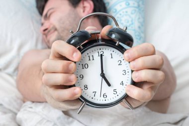Çalar saati olan yorgun bir adam erken kalkmak istemez.