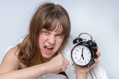 Çalar saati olan kızgın kadın uyanmak ve işe gitmek istemiyor.