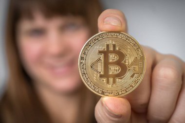 Elinde altın bitcoin olan kadın - kripto para kavramı