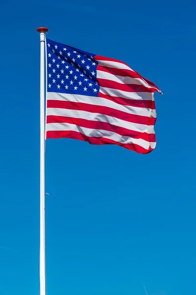 Американский флаг в голубом небе — стоковое фото