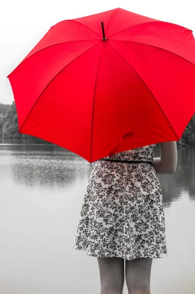 Mädchen mit rotem Regenschirm steht am Teich — Stockfoto