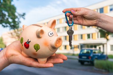 Real estate agent giving home keys to a new property owner, who 