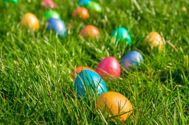 Yeşil çimenlerin üzerinde renkli Paskalya yumurtaları