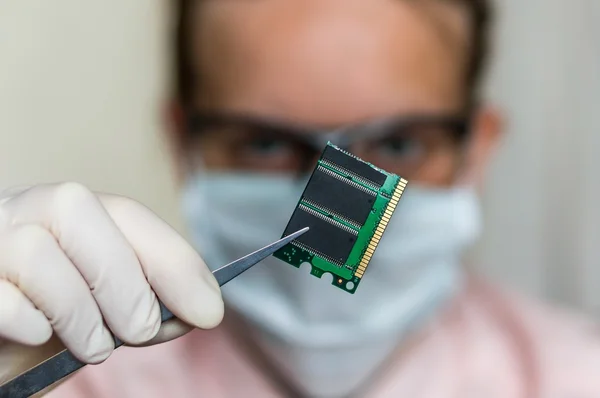 Scientist holding and examining damaged electrical component — Stock Photo, Image