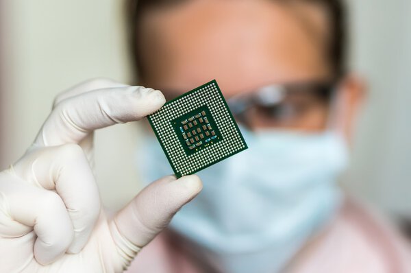 Scientist showing the computer microchip before repairs electron