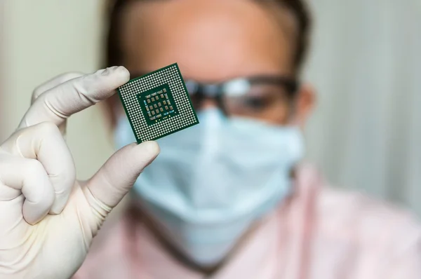 Scientist showing the computer microchip before repairs electron