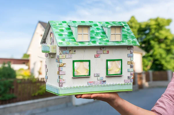 Real estate agent holding model house from paper — Stock Photo, Image