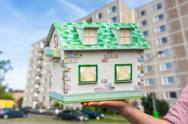 Real estate agent holding model house from paper