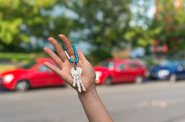 Salesman giving car key to a new owner — Stock Photo, Image