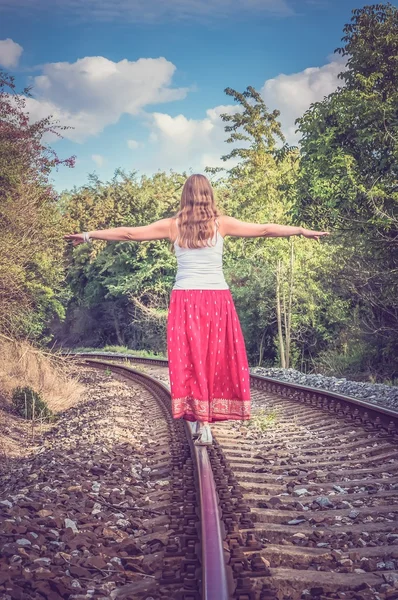 Beautiful young woman walking on the rail — Stock Photo, Image