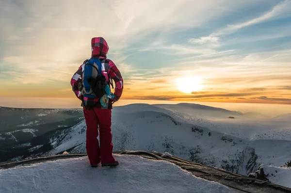 Girl watching at the sunset on the top of mountain — Stock fotografie