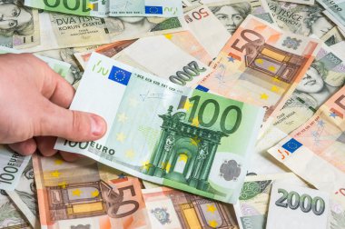 Hand holding 100 euro banknotes