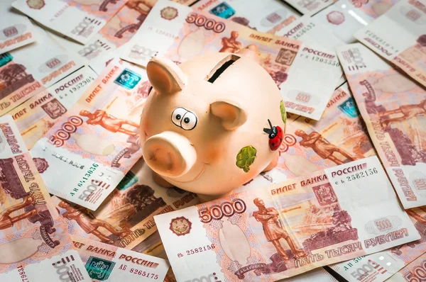 Banco porquinho em uma pilha de notas russas cinco mil — Fotografia de Stock
