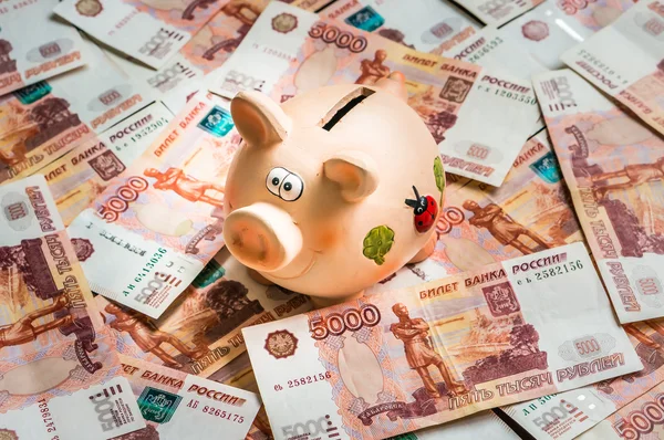 Пигги-банк в куче русских банкнот на пять тысяч. — стоковое фото