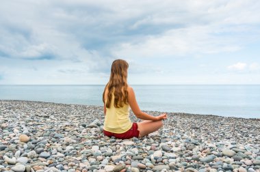 pratik Yoga seashore adlı genç bir kadın