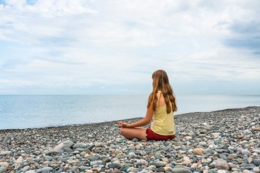 pratik Yoga seashore adlı genç bir kadın