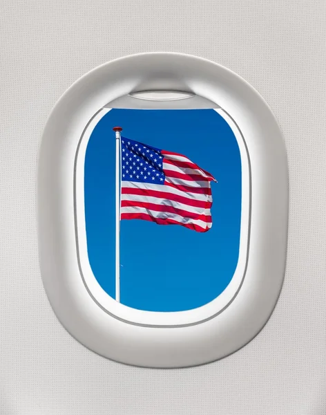 Looking out the window of a plane to the flag of United States — Stock Photo, Image