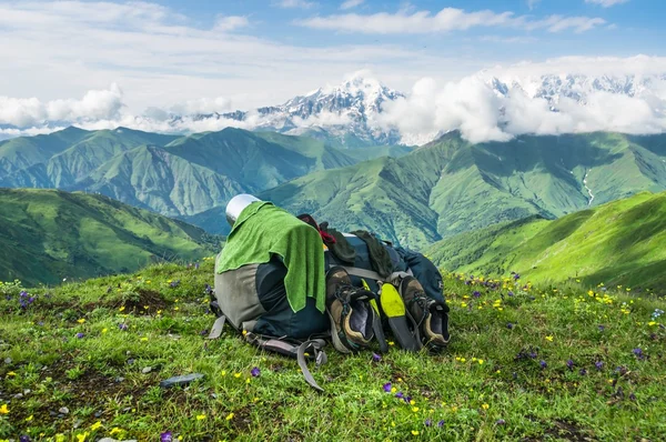 Essuie-tout et chaussures sur sac à dos sur fond de montagnes — Photo