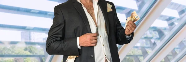 Развращенный бизнесмен в черном костюме и деньги в карманах — стоковое фото