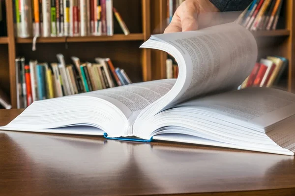 The hand opening and browsing the book pages — Stock Photo, Image