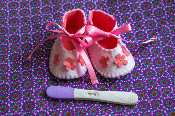 Newborn baby girl booties and pregnancy test