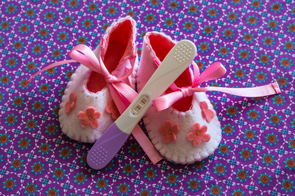 Newborn baby girl booties and pregnancy test