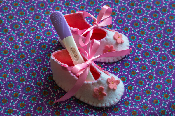Newborn baby girl booties and pregnancy test