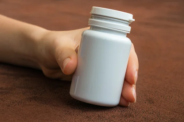 Людська рука тримає пляшку таблеток — стокове фото