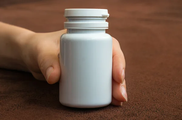 Mão humana segurando uma garrafa de comprimidos — Fotografia de Stock