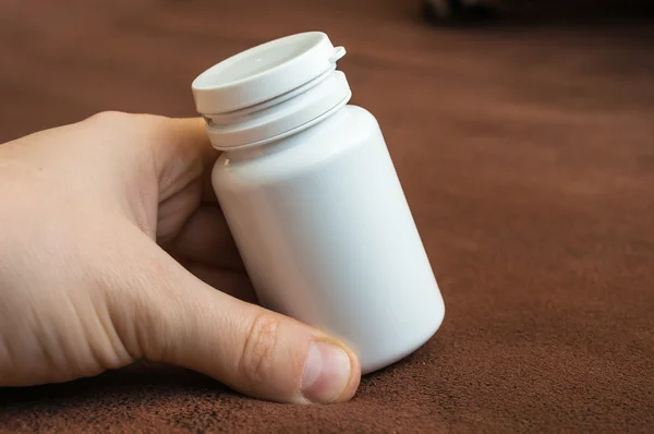 Mano humana sosteniendo una botella de pastillas —  Fotos de Stock