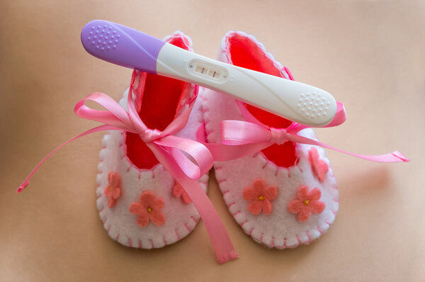 Newborn baby girl booties and pregnancy test