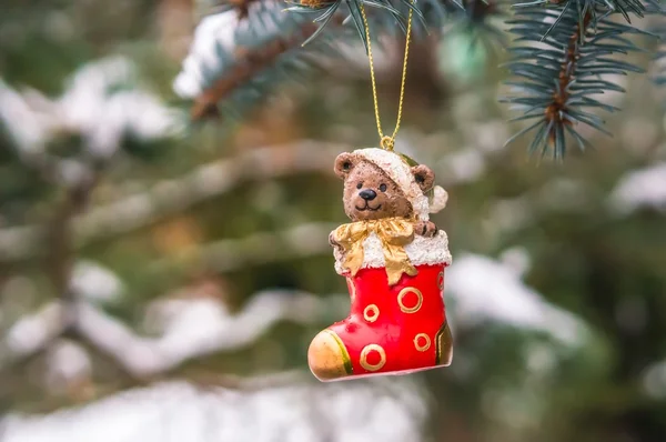 Teddy bear in Christmas sock on snowy branch fir — Stock Photo, Image
