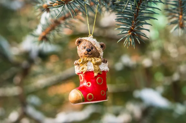 Teddy bear in Christmas sock on snowy branch fir — Stock Photo, Image