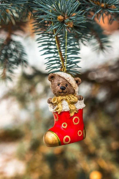 Teddy bear in Christmas sock on snowy branch fir — Stock Photo, Image